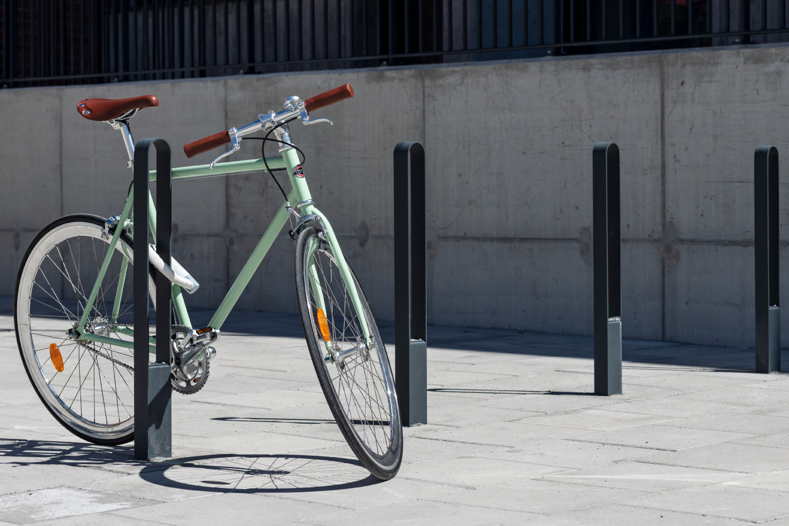 LUX pyörätelinepollari runkolukolla, huomiotaherättämätön muotoilu julkisella alueella, vihreä pyörä kiinni valkoisella runkolukolla