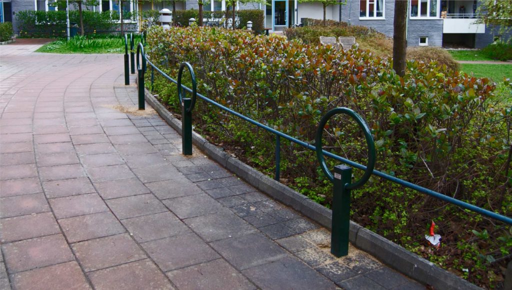 Cyklos pyöräteline OMEGA sivusta, asennettu ilman pidikkeitä ja vihreä väritys, toimii myös aitana