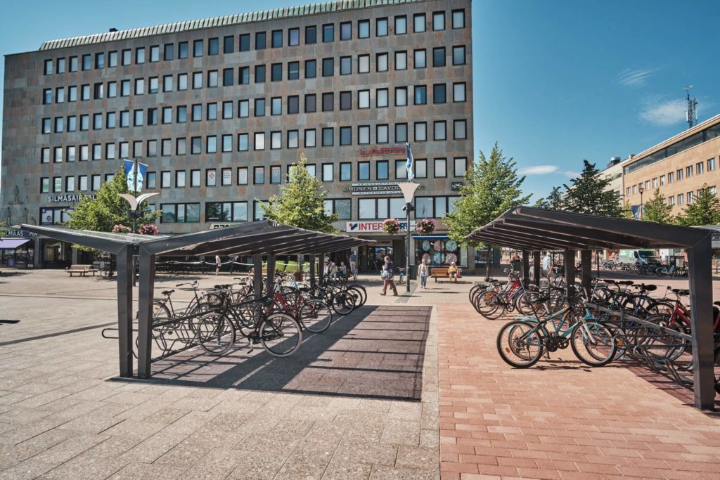 Kartiomaiset kattotuolit, lasimainen ja läpinäkyvä katos LIGHT pyöräkatoksella, Joensuun tori kesällä 2019