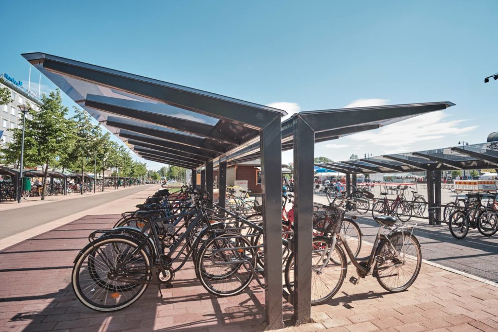 Kartiomaiset kattotuolit, lasimainen ja läpinäkyvä katos LIGHT pyöräkatoksella, Joensuun tori kesällä 2019