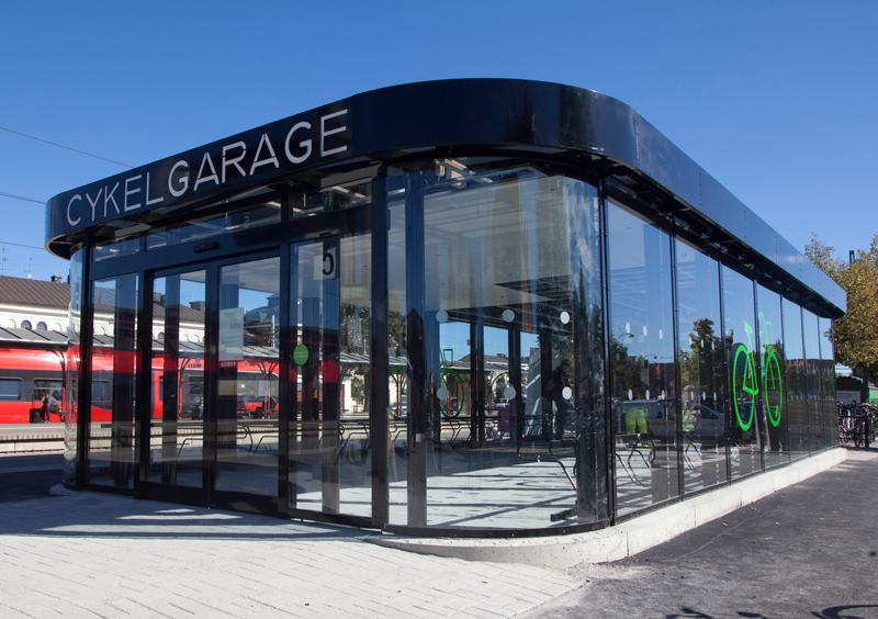 Cykelgarage FLOW med glasväggar och automatisk skjutdörr på tågstationen i Katrineholm