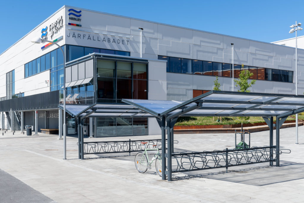 Dubbelsidigt cykeltak YPSILON från Cyklos utanför Järfällabadet i Järfälla tillsammans med cykelställ DELTA där en parkerad cykel är fastlåst i ramen