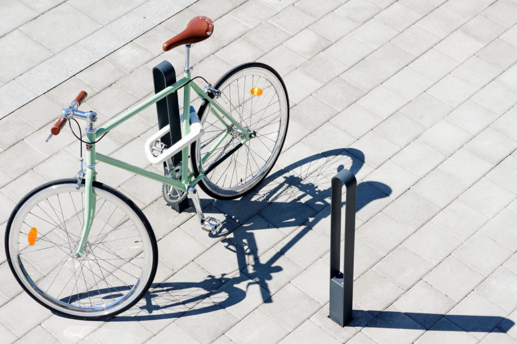 Två cykelpollare LUX från Cyklos där det vid en av pollarna står en grön cykel