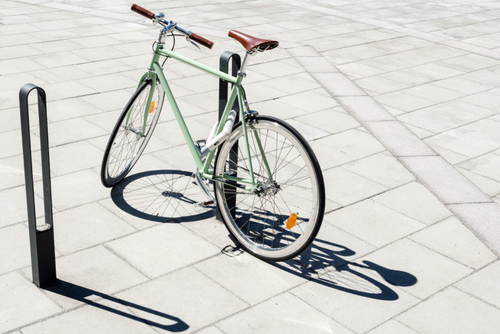 Två cykelpollare LUX från Cyklos där det vid en av pollarna står en grön cykel