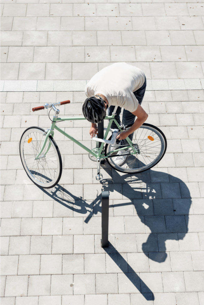 Cyklist parkerar en grön cykel vid en cykelpollare LUX från Cyklos