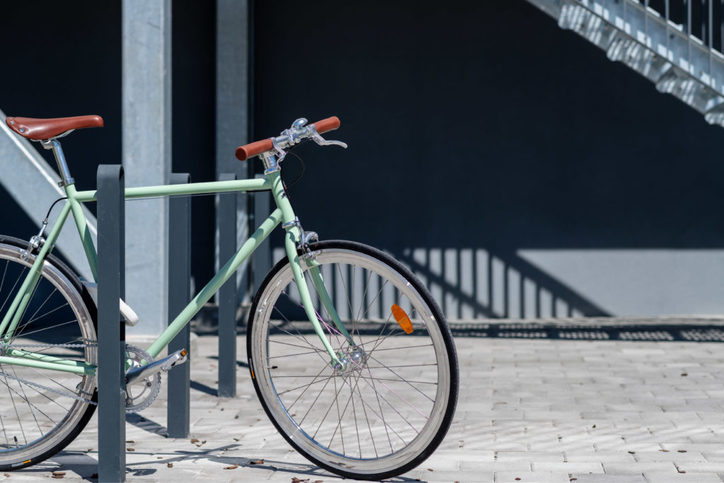 Fyra cykelpollare LUX från Cyklos där det vid en av pollarna står en grön cykel