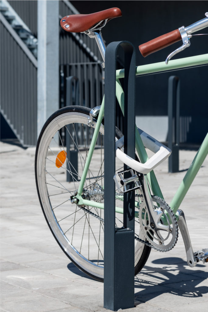 Cykelpollare LUX från Cyklos där en grön cykel står parkerad