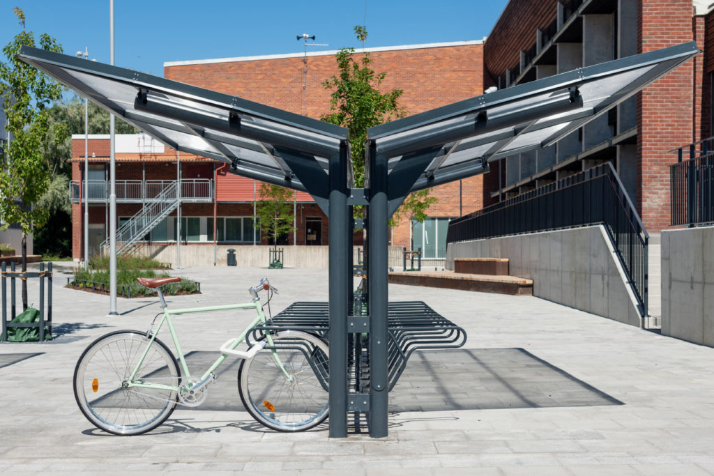 Dubbelsidigt cykeltak YPSILON från Cyklos sett från sidan tillsammans med cykelställ DELTA där en parkerad cykel är fastlåst i ramen