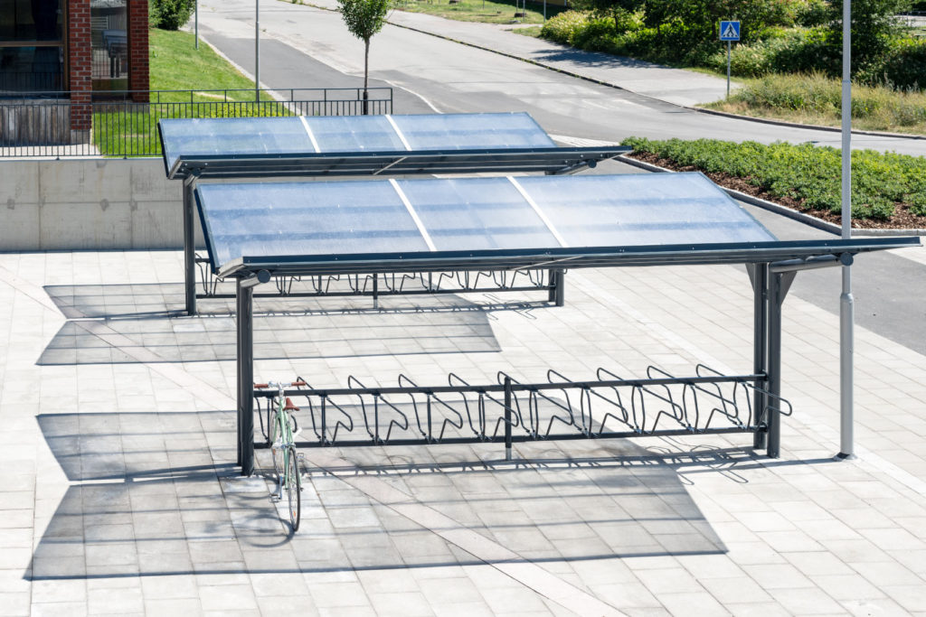 Dubbelsidigt cykeltak YPSILON från Cyklos tillsammans med cykelställ DELTA där en parkerad cykel står