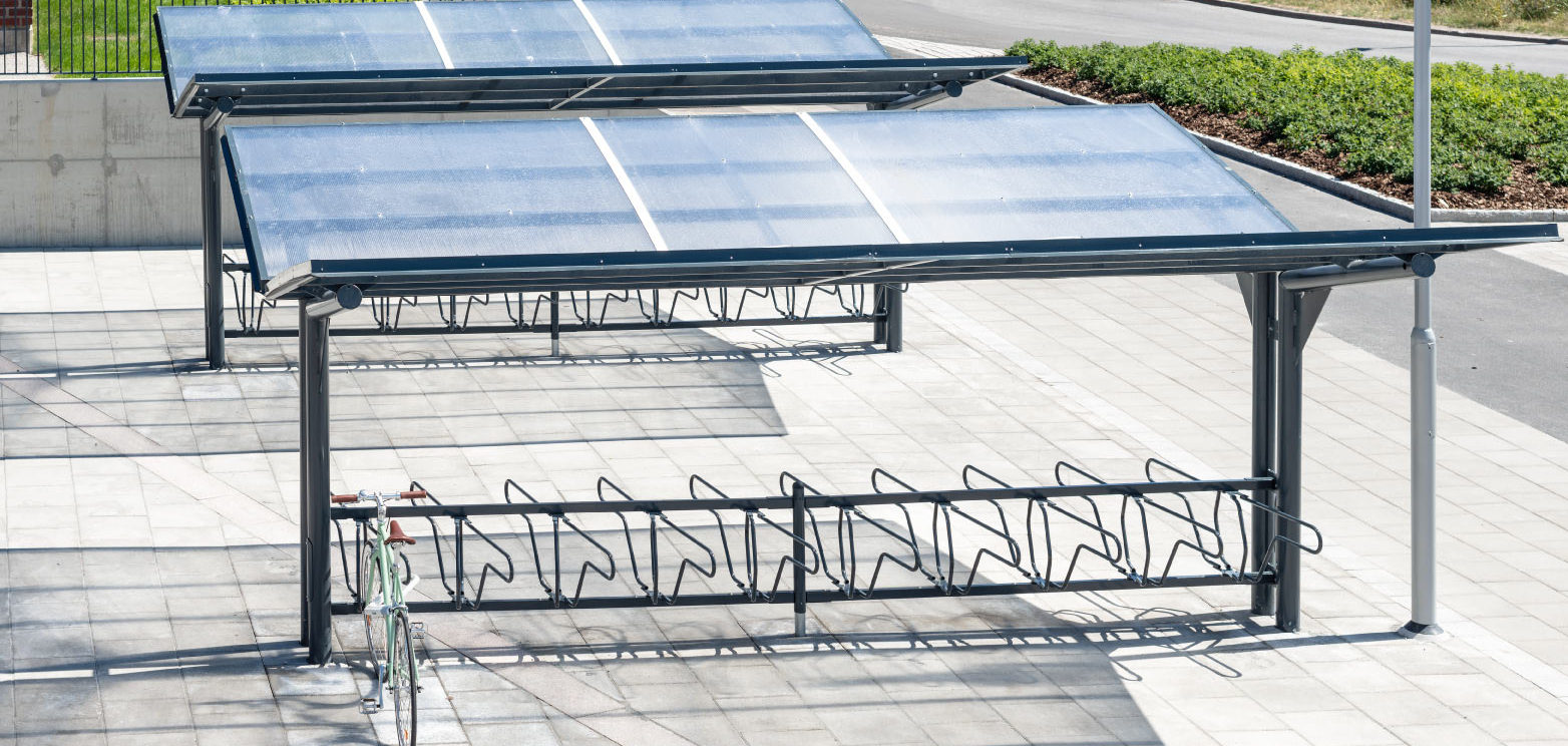 Dubbelsidigt cykeltak YPSILON från Cyklos tillsammans med cykelställ DELTA där en parkerad cykel står
