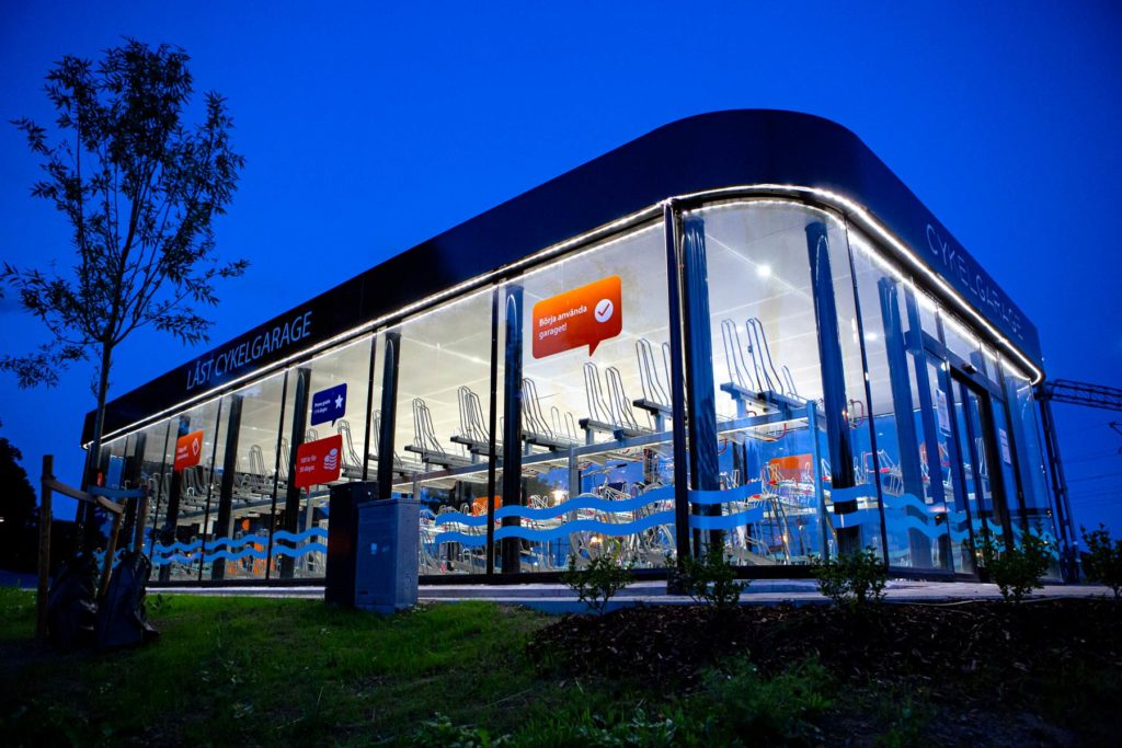 Trygg cykelparkering i ett cykelgarage med väggar av glas och stark belysning